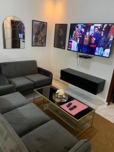 sala de estar con sofá y TV de pantalla plana en The Retreat Apartments, en Brusubi