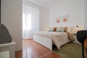 Un dormitorio blanco con una cama y un escritorio. en 186 - Casa Aureliana VISTA MARE a Lavagna 100 metri dal Mare e spiaggia - PARCHEGGIO GRATIS INCLUSO, en Lavagna