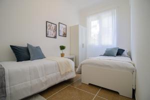 Un dormitorio con dos camas y una ventana. en 186 - Casa Aureliana VISTA MARE a Lavagna 100 metri dal Mare e spiaggia - PARCHEGGIO GRATIS INCLUSO, en Lavagna