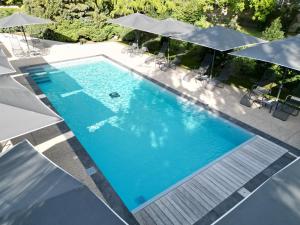an overhead view of a swimming pool with umbrellas at Aux Deux Clefs Hostellerie Groff in Biesheim