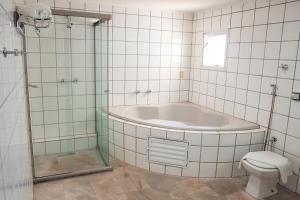 y baño con bañera, aseo y ducha. en Sakr Hotel en Penápolis