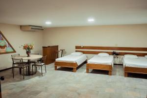 um quarto de hospital com duas camas e uma mesa em Sakr Hotel em Penápolis