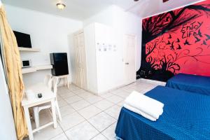 hotel trinidad في لا سيبا: غرفة نوم بسرير ازرق وجدار احمر
