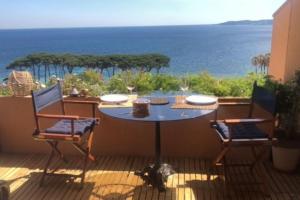 d'une table et de deux chaises sur un balcon donnant sur l'océan. dans l'établissement Appartement vue mer, accès privé plage, piscine, à Sainte-Maxime