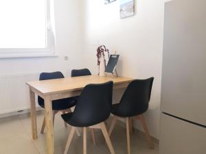 a wooden table with four chairs and a refrigerator at Eichbachgasse 38 in Graz