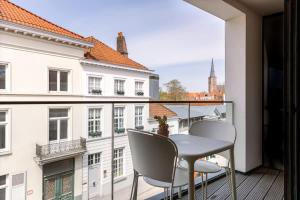 balcón con mesa, sillas y vistas en Bonrepo Room 103 en Bruges