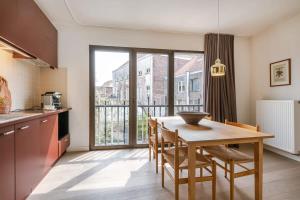 eine Küche mit einem Tisch und Stühlen sowie einem großen Fenster in der Unterkunft Bonrepo Room 103 in Brügge