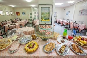 a table with many plates of food on it at HOTEL AZZURRA in Senigallia