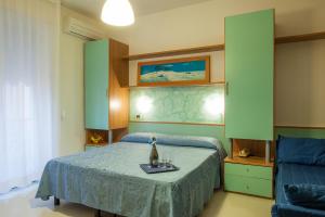 a bedroom with a bed with a blue bedspread at HOTEL AZZURRA in Senigallia