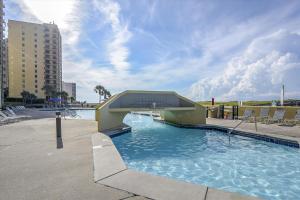 una piscina con un puente en el agua en Phoenix 6 Unit 215, en Orange Beach