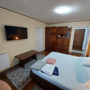 ein kleines Schlafzimmer mit einem Bett und einem Tisch in der Unterkunft Apartament central 2 camere in Eforie Nord