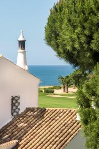 een vuurtoren bovenop een wit gebouw bij Mng Elliott37 in Vale do Lobo