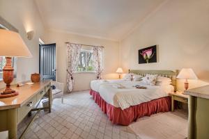 een hotelkamer met een groot bed en een bureau bij Mng Elliott37 in Vale do Lobo +2 foto's