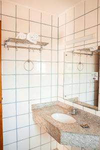 uma casa de banho com um lavatório e um espelho em Sakr Hotel em Penápolis