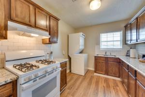 a kitchen with white appliances and wooden cabinets at Cozy Lake Charles Apartment 2 Mi to Downtown in Lake Charles
