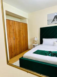 een slaapkamer met een bed en een grote spiegel bij The Cosy Corner in Kisii