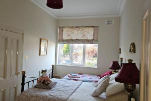 sypialnia z 2 łóżkami i oknem w obiekcie Grove Cottage at The Lodge w mieście Tullow