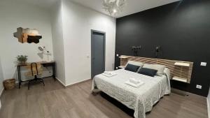 Habitación en blanco y negro con cama y escritorio. en Hostal Inter Plaza Mayor, en Madrid
