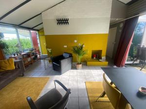 een woonkamer met een bank en een tafel en stoelen bij Zuid Limburg Huisje Josefien in Simpelveld