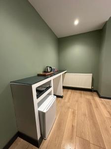an empty room with a white desk and a wooden floor at Heaven Inn Airport Hotel in Arnavutköy