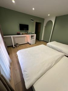 a hotel room with two beds and a flat screen tv at Heaven Inn Airport Hotel in Arnavutköy