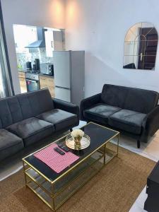 a living room with two couches and a coffee table at The Retreat Apartments in Brusubi