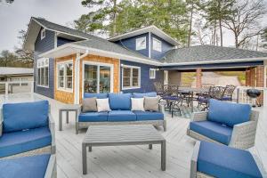 un patio con sofás y mesas azules y una casa en Hot Springs Lakefront Home with Dock and Water Views!, en Hot Springs