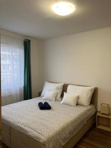 a bed with a pair of shoes sitting on it at Lux Cordia Apartment with free parking in Budapest