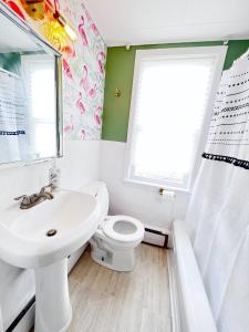 łazienka z umywalką, toaletą i oknem w obiekcie The Hollywood Suite Downtown, BeverlyHills Vibe w mieście Fredericton
