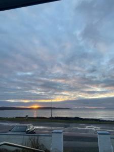 un coche aparcado en un estacionamiento junto al agua en Myrtle Bank Hotel, en Gairloch