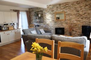 ein Wohnzimmer mit einem Sofa und einem Tisch in der Unterkunft Portclew Cottages in Pembroke