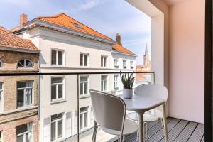 uma mesa e cadeiras numa varanda com vista em Bonrepo Room 104 em Bruges