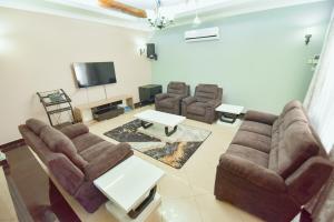 sala de estar con sofá, sillas y TV en GOWON BnB BUNJU, en Nasulo