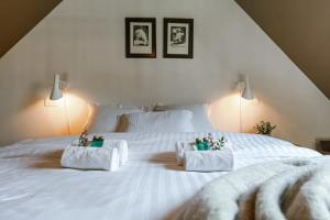 um quarto com uma cama branca e 2 almofadas brancas em Bonrepo Room 104 em Bruges