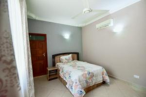 um pequeno quarto com uma cama e uma porta em GOWON BnB BUNJU em Nasulo