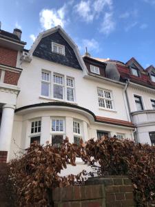 duży biały dom z czarnym dachem w obiekcie Ferienhaus ON90 w mieście Wilhelmshaven