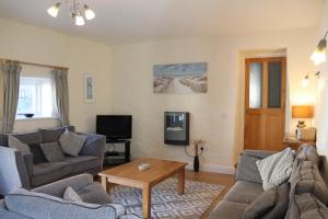 ein Wohnzimmer mit 2 Sofas und einem Tisch in der Unterkunft Portclew Cottages in Pembroke