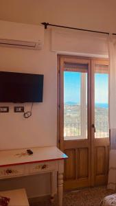 Villagrande StrisailiにあるB&B Aria Onaの薄型テレビ、窓が備わる客室です。