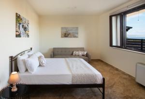 um quarto com uma cama, um sofá e uma janela em Mira Mare em Khlóï