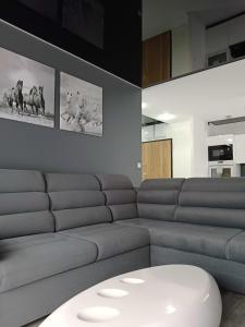 uma sala de estar com um sofá e um banco branco em Apartament Zielony Zakątek Wrocław em Breslávia