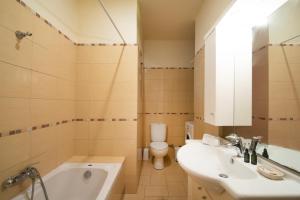 uma casa de banho com um lavatório, um WC e uma banheira em Mira Mare em Khlóï
