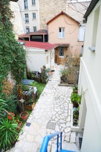a backyard with a stone walkway and a house at Eiffel Tour Cosy Oliver in Paris