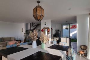 a dining room with a table and a living room at Casa D30 Oasis Bahía Paracas in Pisco