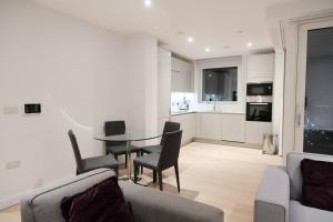 een woonkamer met een tafel en stoelen en een keuken bij Luxury 2B2B in central London in Londen