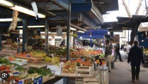 un mercato con persone che camminano per un mercato con frutta e verdura di Casa Dino a Roma