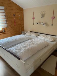 1 Schlafzimmer mit 2 weißen Betten in einem Zimmer in der Unterkunft Blockhaus FerienZauber III in Bromskirchen