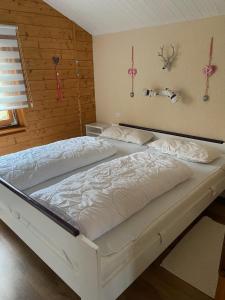 a bedroom with two white beds in a room at Blockhaus FerienZauber III in Bromskirchen