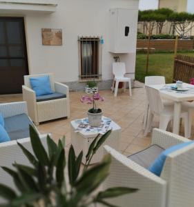 een patio met witte meubels en een tafel en stoelen bij Antica Salina in Porto Clementino