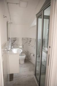 a white bathroom with a toilet and a sink at Dreams in Gragnano
