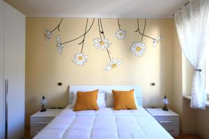 a bedroom with a bed with flowers on the wall at DA MEGGY in Stresa